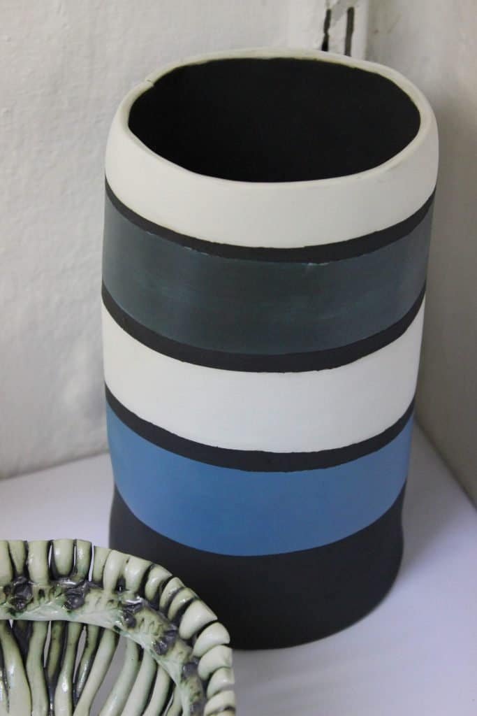 Blue, black and white striped ceramic pot. 